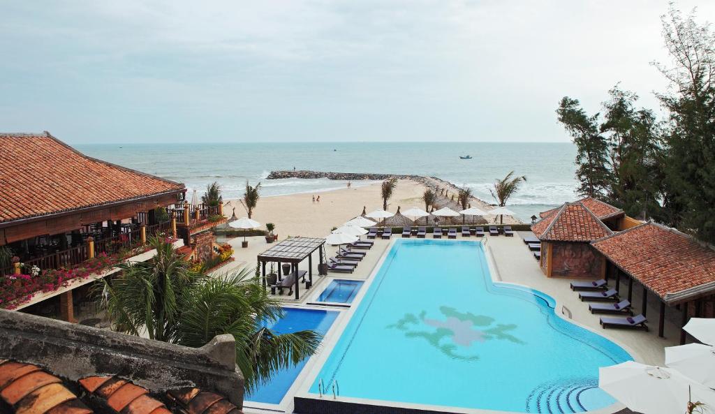 einen Luftblick auf ein Resort mit Pool und Strand in der Unterkunft Poshanu Boutique Resort in Mui Ne