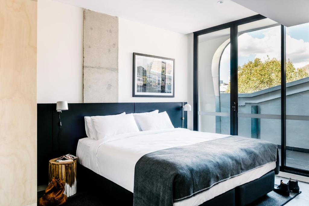 a bedroom with a large bed and a large window at Veriu Broadway in Sydney
