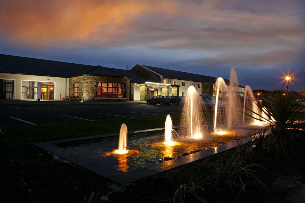 una fuente frente a un edificio por la noche en Broadhaven Bay Hotel, en Belmullet