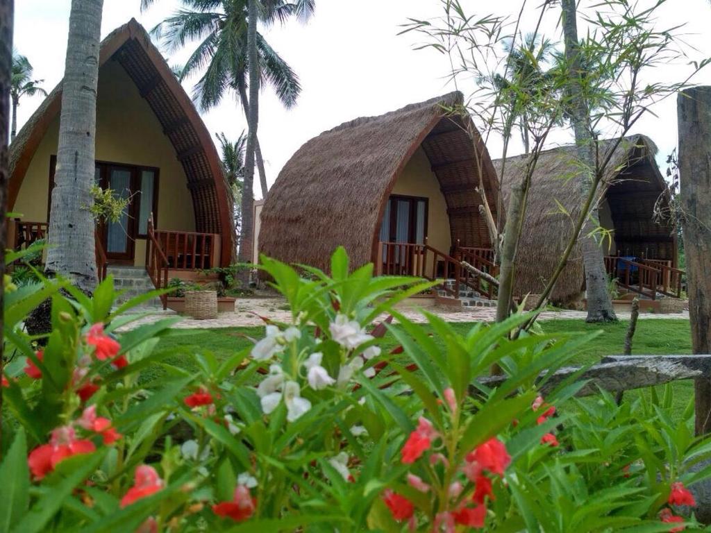 a view of two thatched huts in a garden at Karimun Lumbung in Karimunjawa