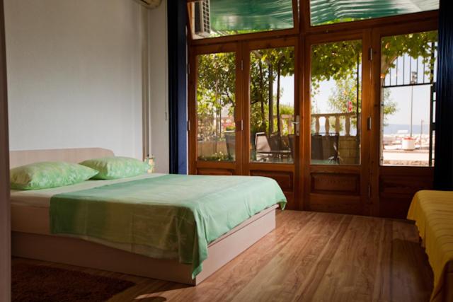 a bedroom with a bed and a large window at Apartmani Denis Vela in Podgora