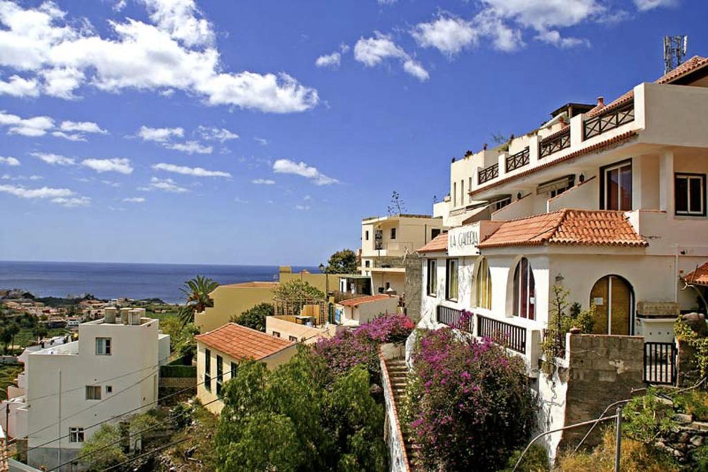 a group of buildings with the ocean in the background at La Galería in Calera