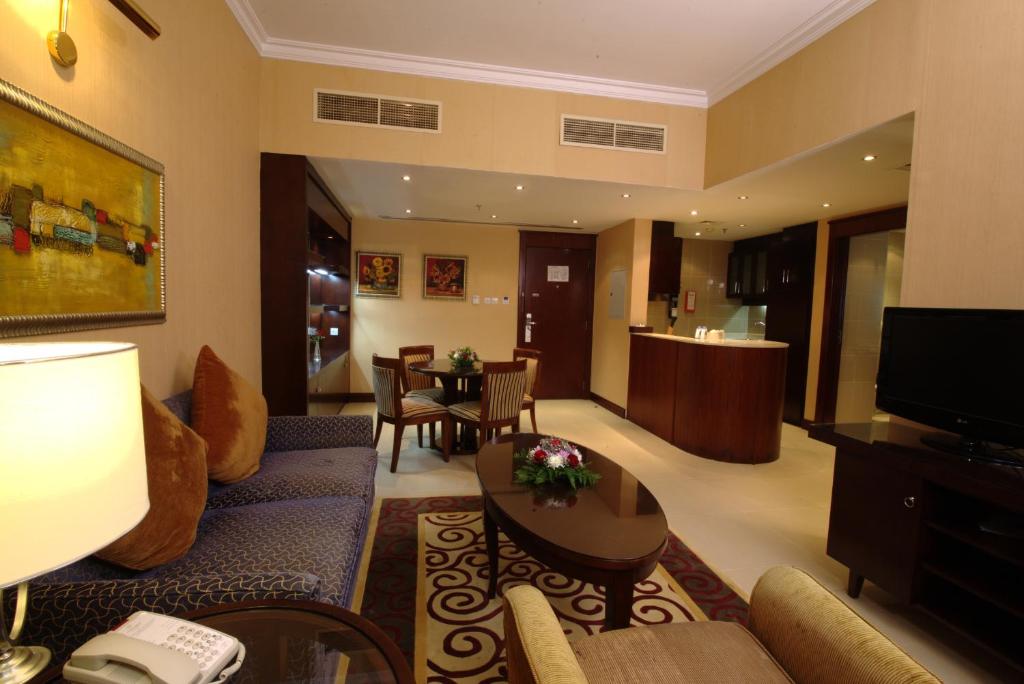 a living room with a couch and a dining room at Concorde Hotel Fujairah in Fujairah