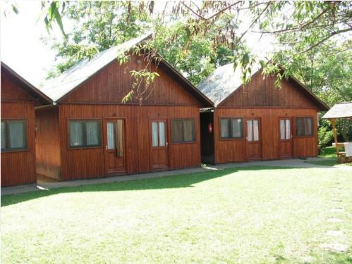 a large wooden house with a yard in front of it at Faház Motel in Abádszalók