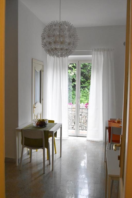una sala da pranzo con tavolo e lampadario pendente di sophie a Salerno