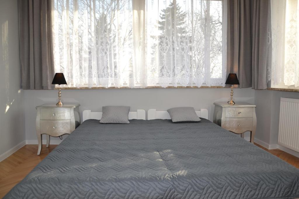 グダニスクにあるBursztynowa Wyspaのベッドルーム1室(ベッド1台、ナイトスタンド2台、窓付)