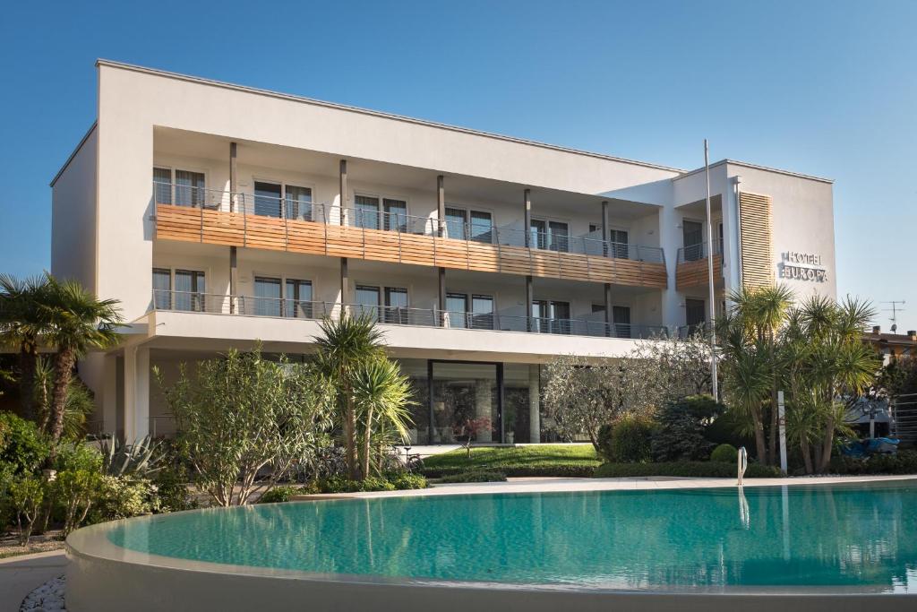 a building with a swimming pool in front of it at Hotel Europa in Sirmione