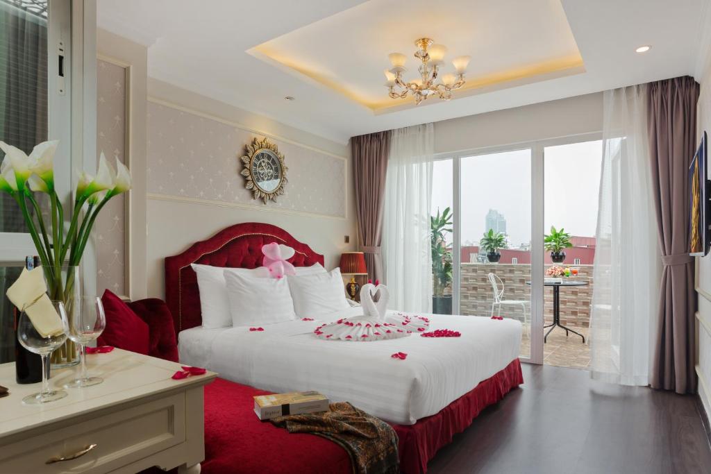 een slaapkamer met een groot wit bed met een rood hoofdeinde bij Luxury Old Quarter Hotel & Gym in Hanoi