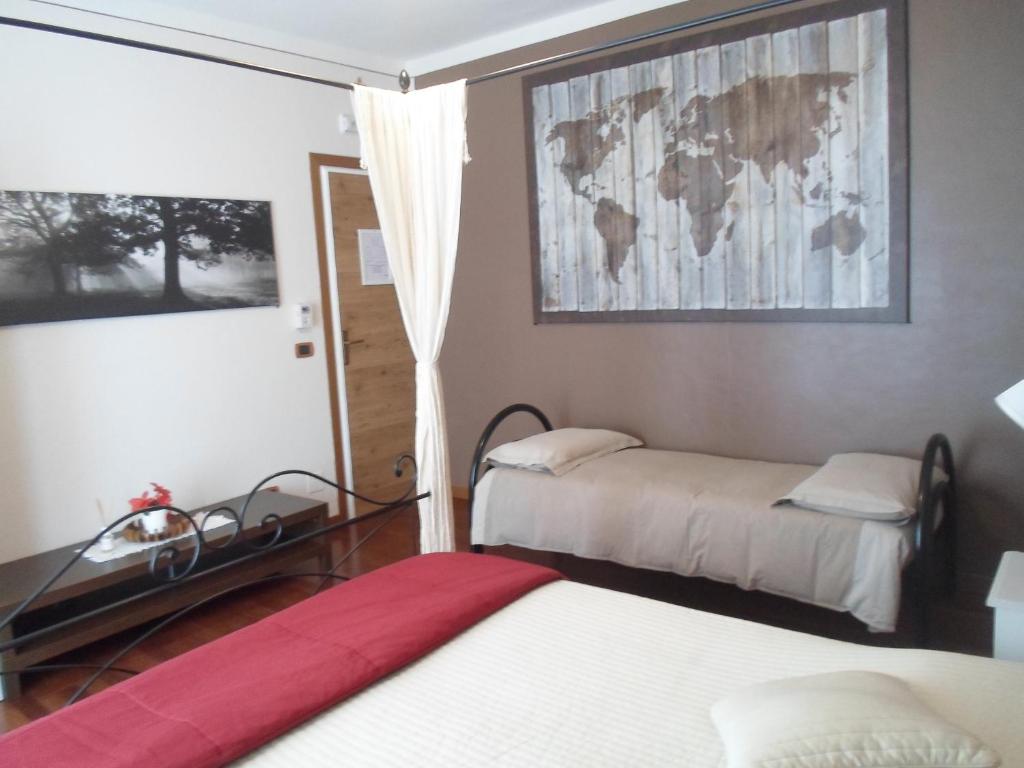 1 dormitorio con 2 camas y una ventana con una pintura en Antica Trattoria del Boden, en Ornavasso