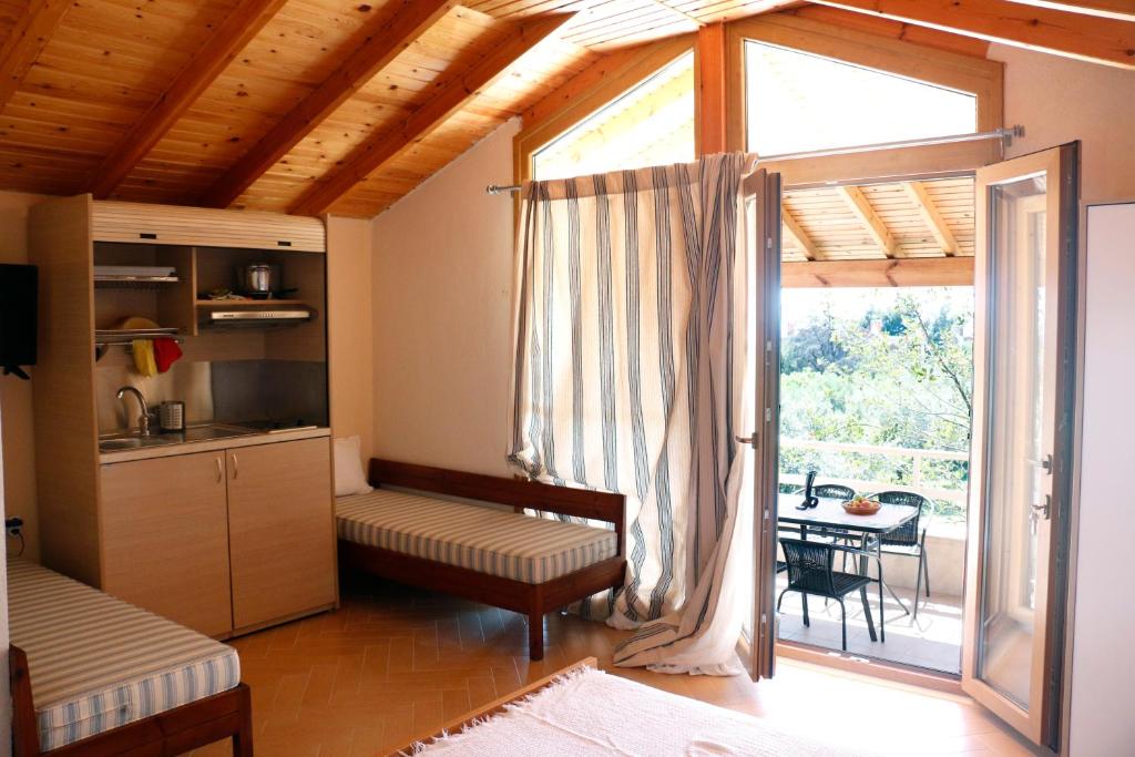 salon z kuchnią i dużym oknem w obiekcie Agios Mamas Resort w mieście Nea Potidaea