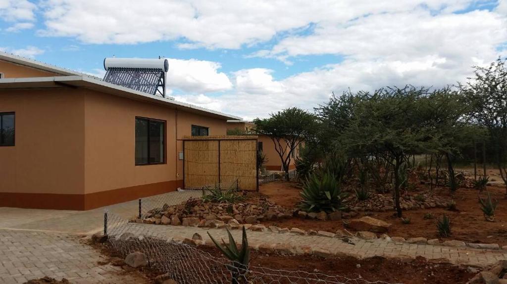 ein Haus mit einem Zaun davor in der Unterkunft Cheetah View Lodge in Otjiwarongo