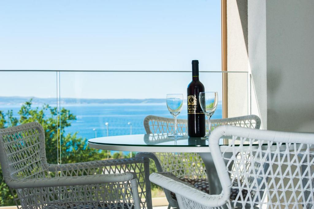 a table with a bottle of wine and two glasses at Apartment Morska vila in Split