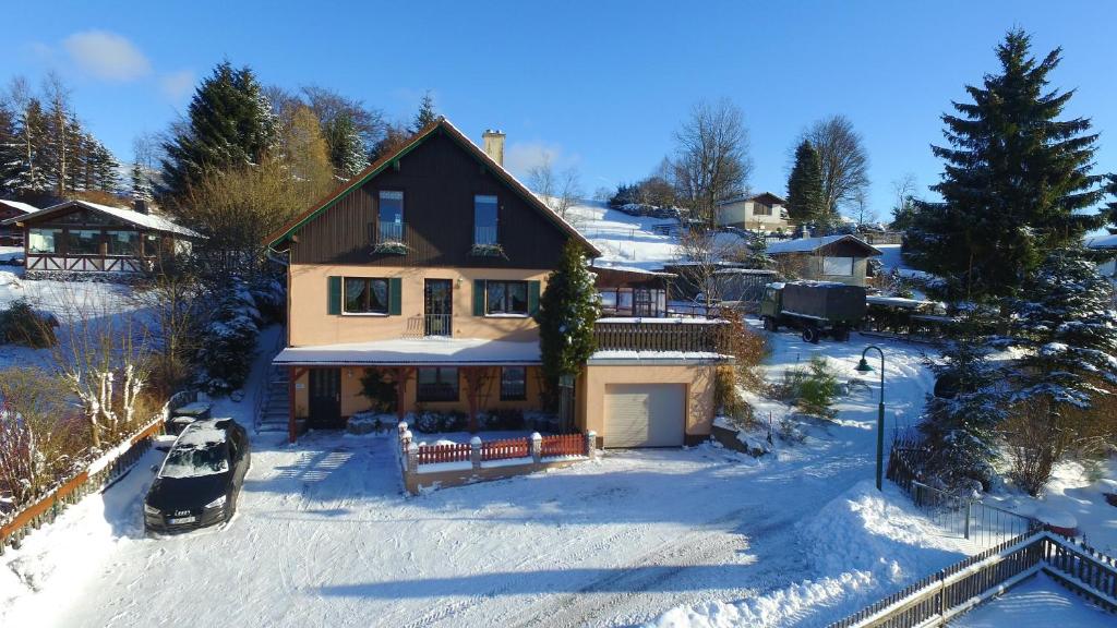 a house in the snow with a car at Ferienwohnung Ritter in Schmiedefeld am Rennsteig