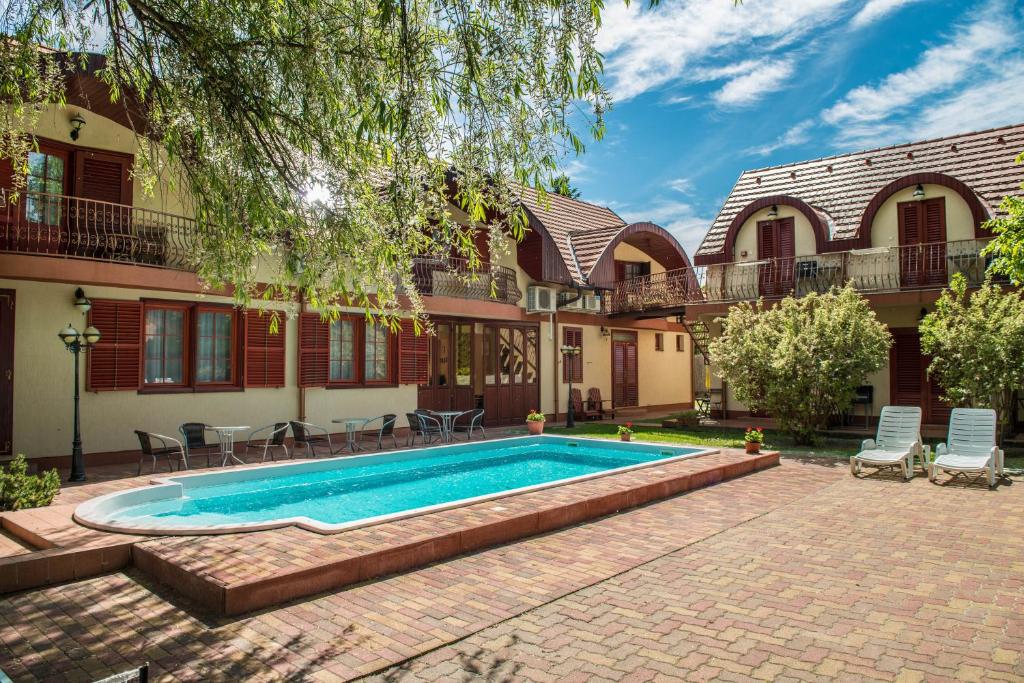 a swimming pool in front of a house at Marina Panzio in Siófok