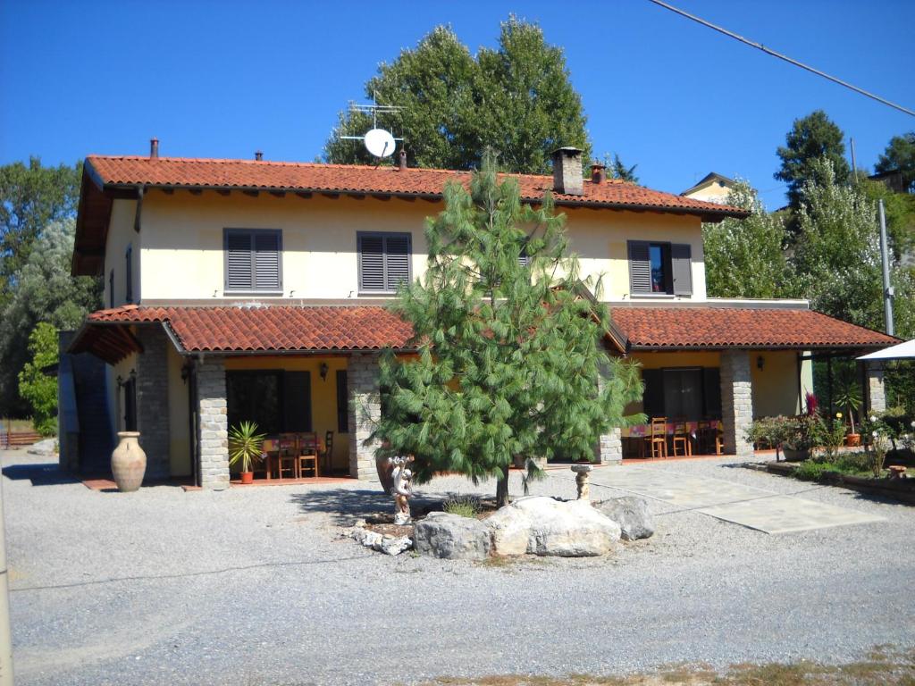 una casa con un árbol delante de ella en Locanda Contrada dei Fattori, en Cairo Montenotte