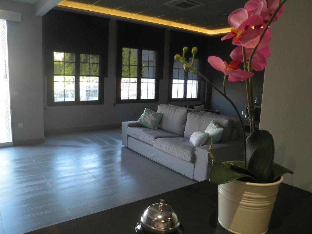a living room with a couch and a vase with flowers at Apartamentos Santa Clara in Alhaurín de la Torre