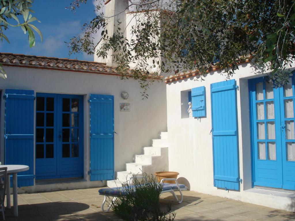 ein weißes Gebäude mit blauen Türen und Treppen in der Unterkunft Le Buzet Bleu Bed & Breakfast in Noirmoutier-en-l'lle