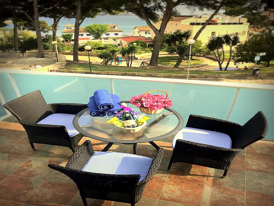 una mesa y sillas con flores en el patio en Apartamentos Petit Blau, en Paguera