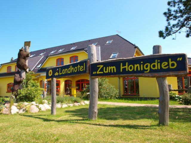 ein Haus mit einem Schild davor in der Unterkunft Landhotel zum Honigdieb in Ribnitz-Damgarten
