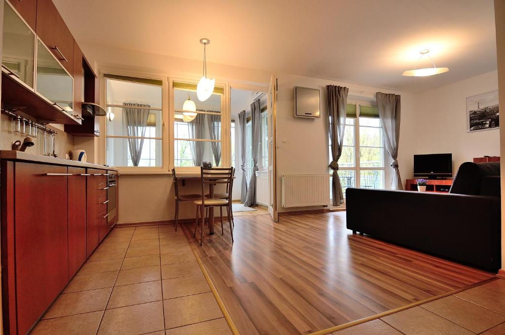 kuchnia i salon z drewnianą podłogą w obiekcie Victus Apartamenty, Apartament Petit w mieście Sopot