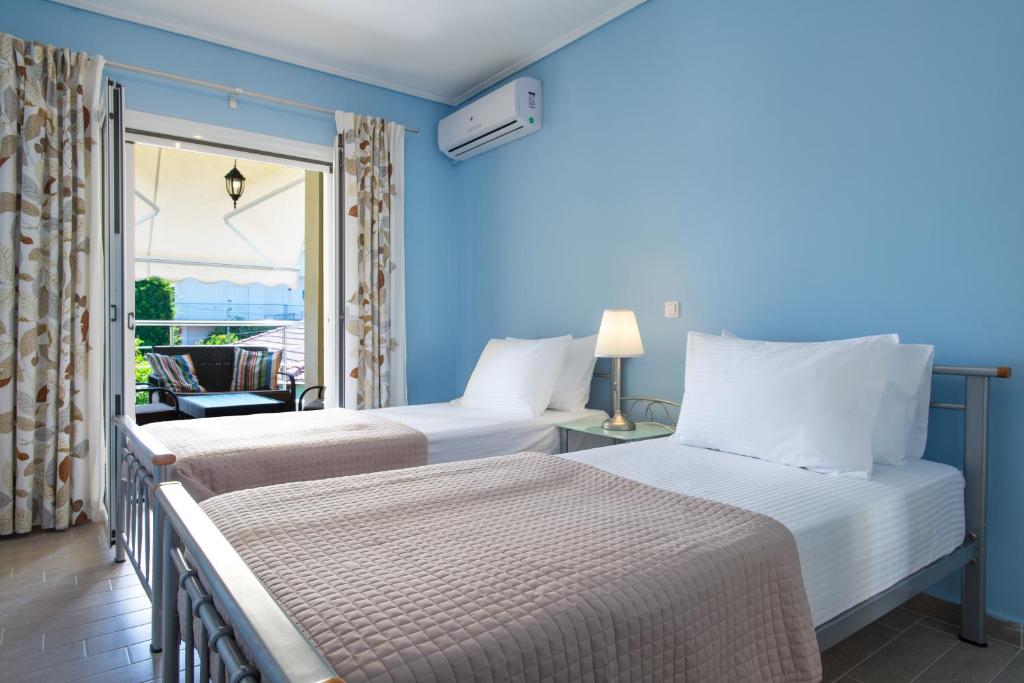 2 łóżka w pokoju z balkonem w obiekcie Diamante Beachfront Suites w mieście Xylokastron