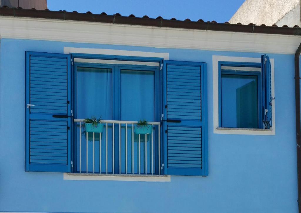 サンタ・テレーザ・ガッルーラにあるCasa Vacanze Danielaのブルーハウス 2つの窓(ブルーシャッター付)