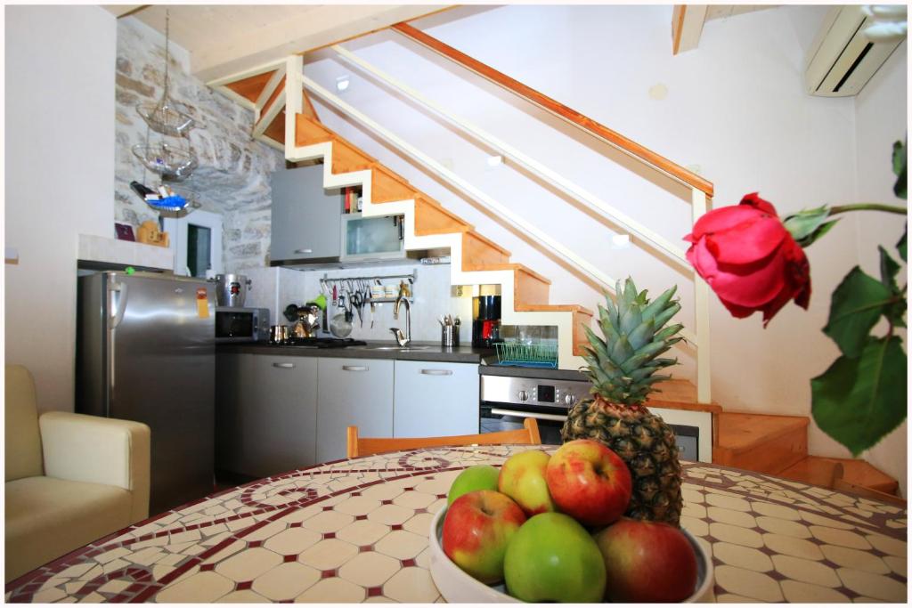 una cocina con una mesa con un bol de fruta. en Apartment Villa Liliput, en Kaštela