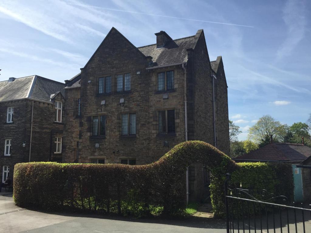 um grande edifício de tijolos com arbustos à frente em Mirfield Monastery B&B em Mirfield