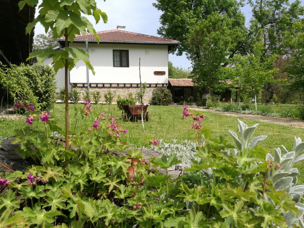 un jardín frente a una casa blanca en Complex Ovchaga en Asparukhovo