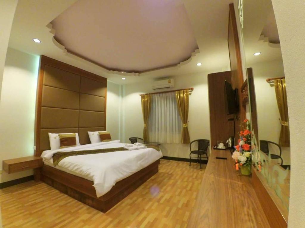 ein Schlafzimmer mit einem großen Bett in einem Zimmer in der Unterkunft Dusita Grand Resort in Hat Yai