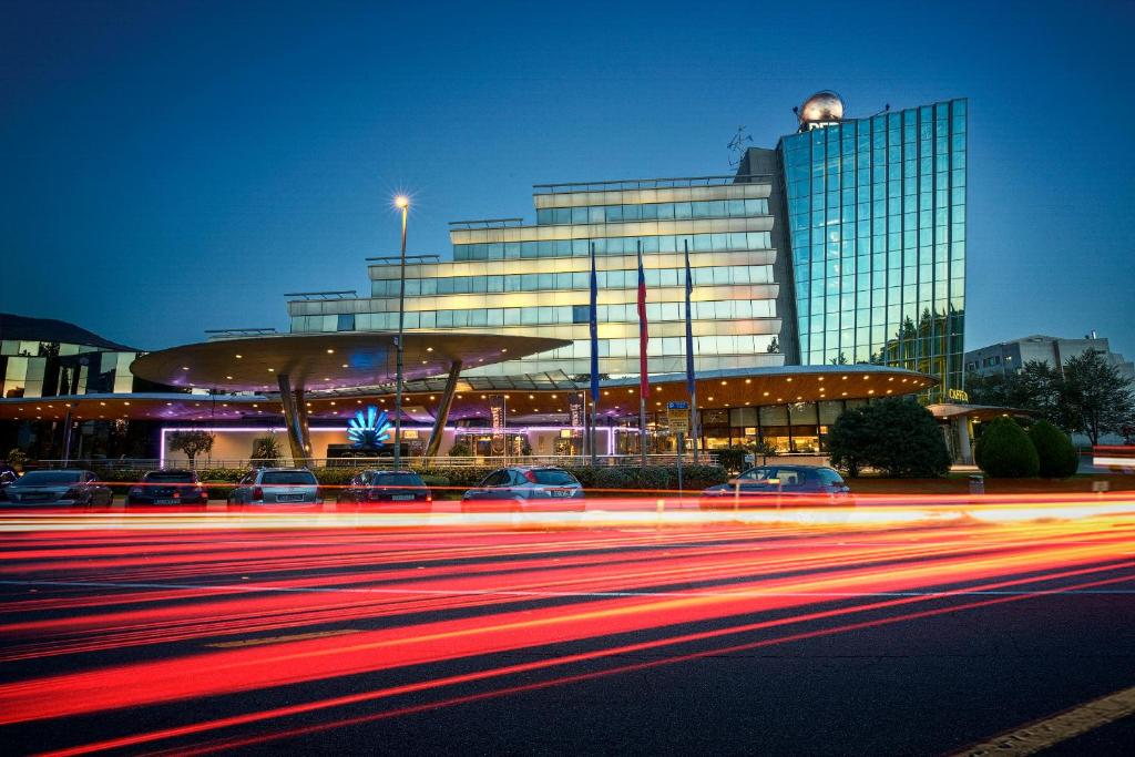 a building with cars parked in front of a street at Perla, Resort & Entertainment in Nova Gorica