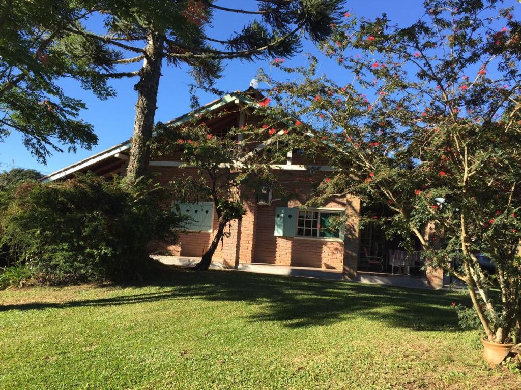 a house with a lawn and trees in front of it at Sitio da Paz Celestial in Nova Petrópolis