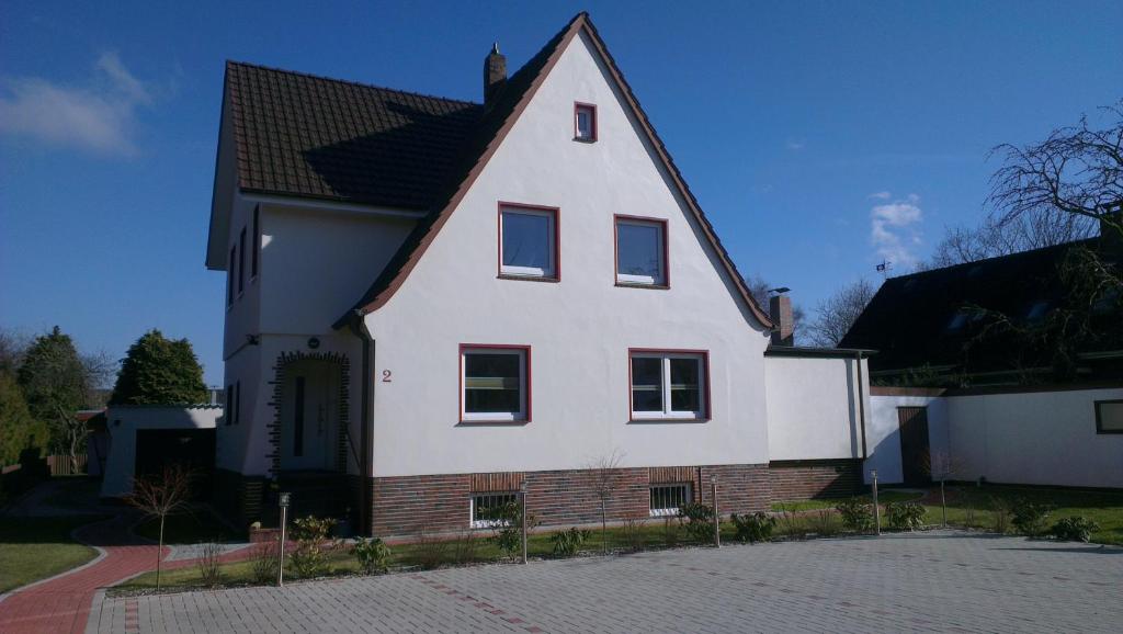 una casa blanca con techo negro en Sahlenburger Ferienhaus, en Cuxhaven