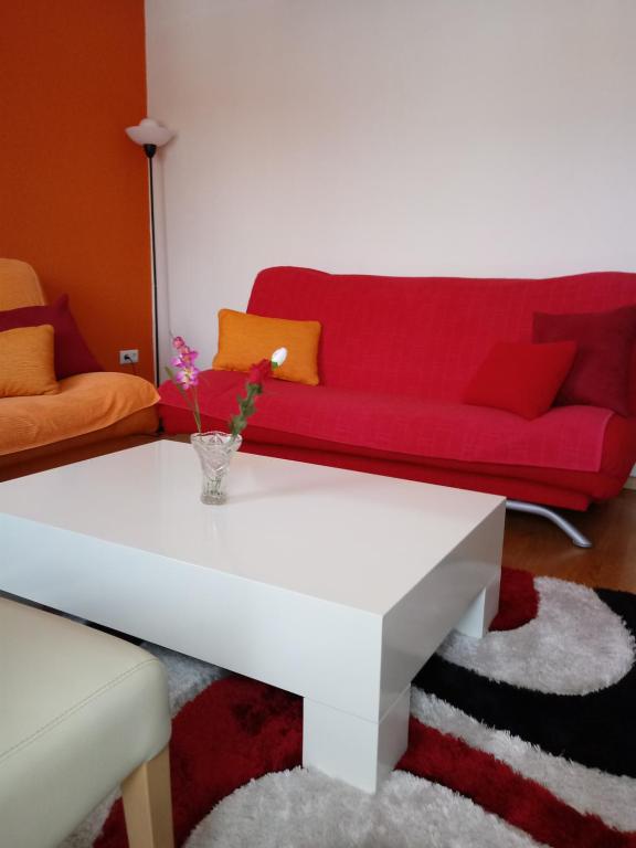 a living room with a red couch and a table at Apartments Stan in Sarajevo