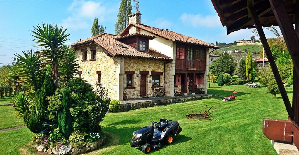 une moto garée devant une maison dans l'établissement Asturias Apartamentos Rurales Naveces, à Naveces