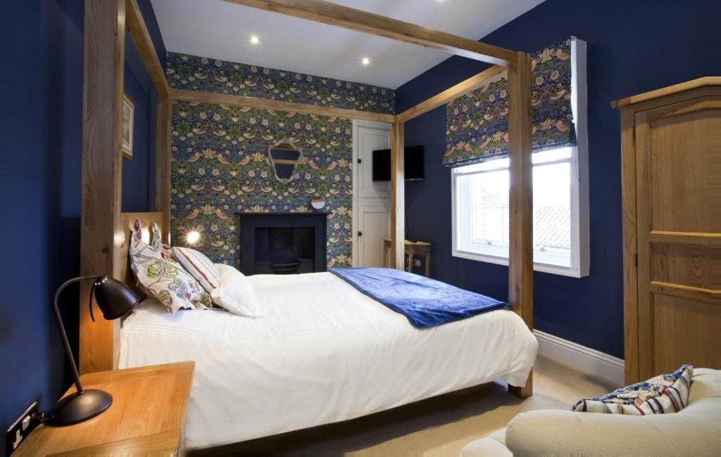1 dormitorio azul con 1 cama y chimenea en The Kings Apartment en York