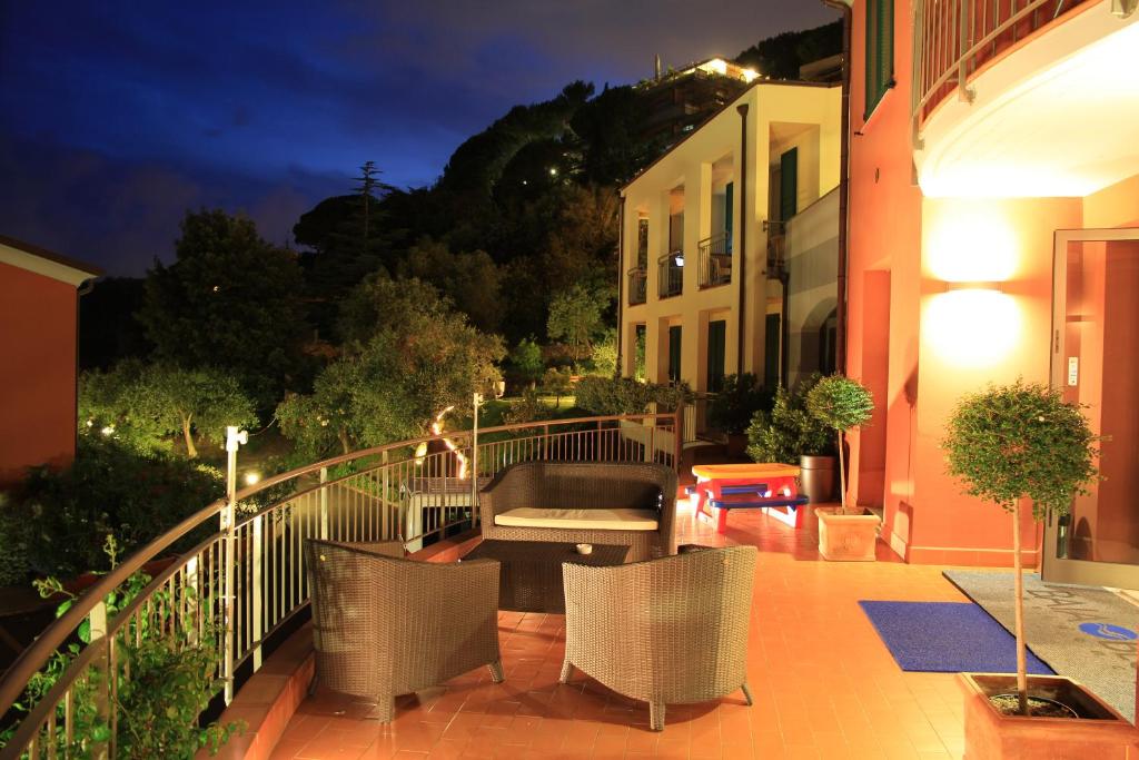 a patio with chairs and a couch on a balcony at night at Baia Blu RTA Residence in Lerici