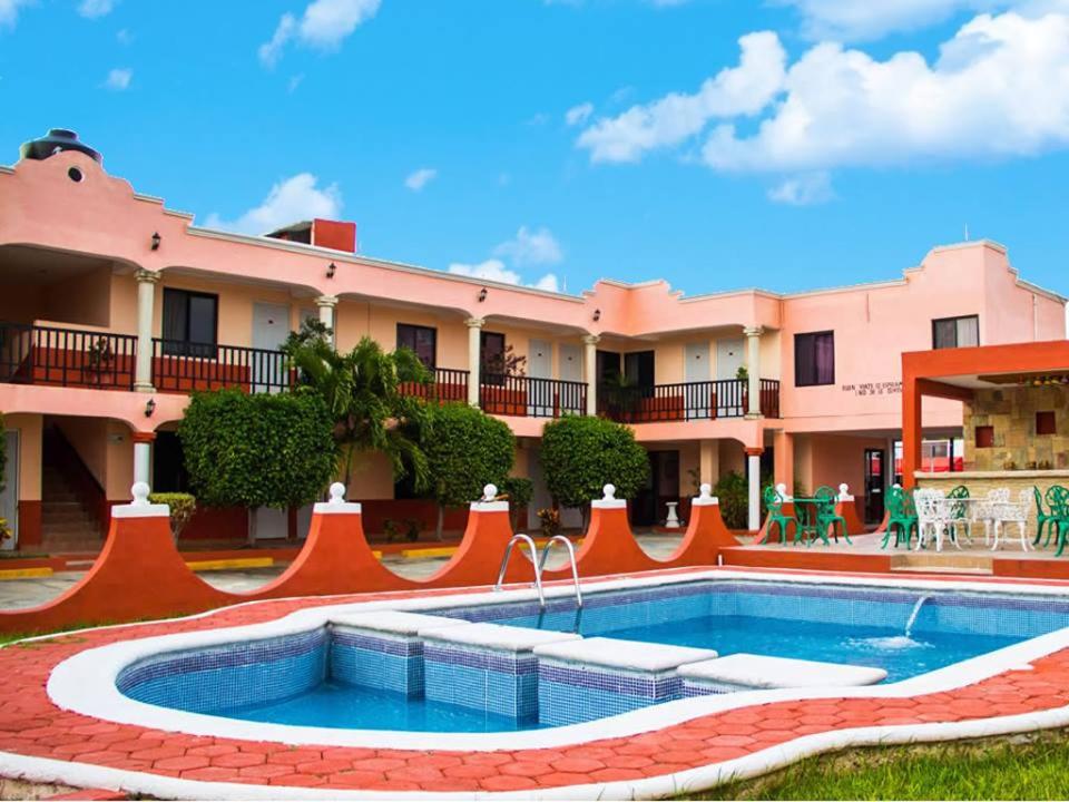 un complejo con piscina frente a un edificio en Hotel Hacienda Cortes en Mérida