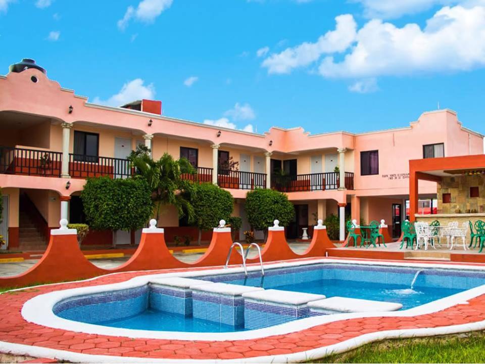 un complexe avec une piscine en face d'un bâtiment dans l'établissement Hotel Hacienda Cortes, à Mérida