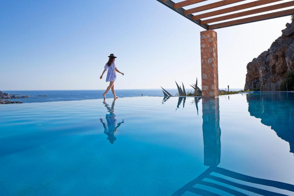 a woman walking on top of a pool of water at Elafonisi Villas in Livadia