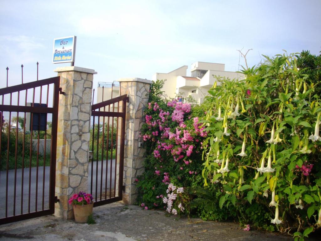 a gate with flowers in front of a building at Stella Marina Sea & Sun in Cefalù
