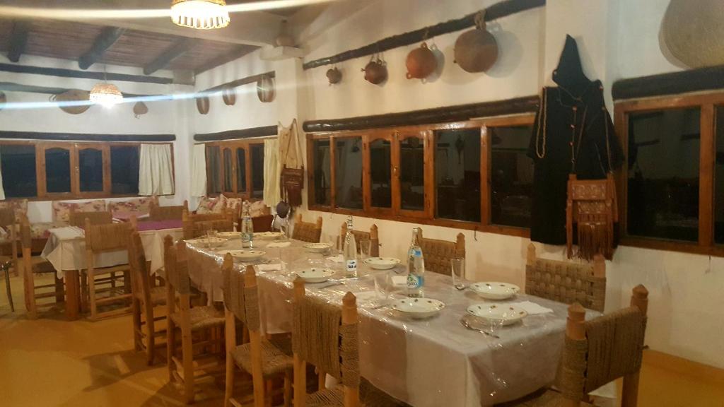 un comedor con una mesa larga y sillas en Ferma Jebala Ecolodge, en Kitane