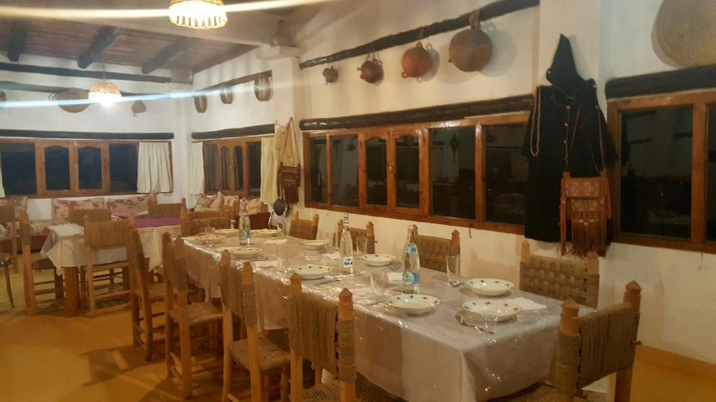 a dining room with a long table and chairs at Ferma Jebala Ecolodge in Kitane