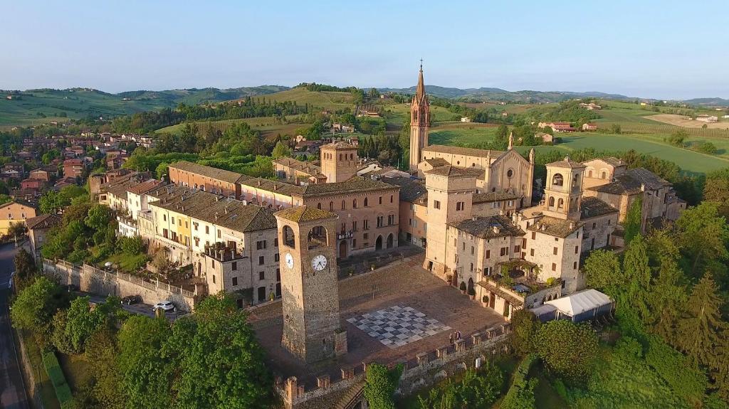 una vista aérea de un edificio con una torre de reloj en B&B il Castello di Vetro en Castelvetro di Modena