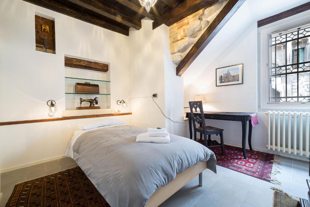威尼斯的住宿－威尼塞塞拉卡薩桑托斯特法諾公寓，一间卧室配有一张床和一张书桌