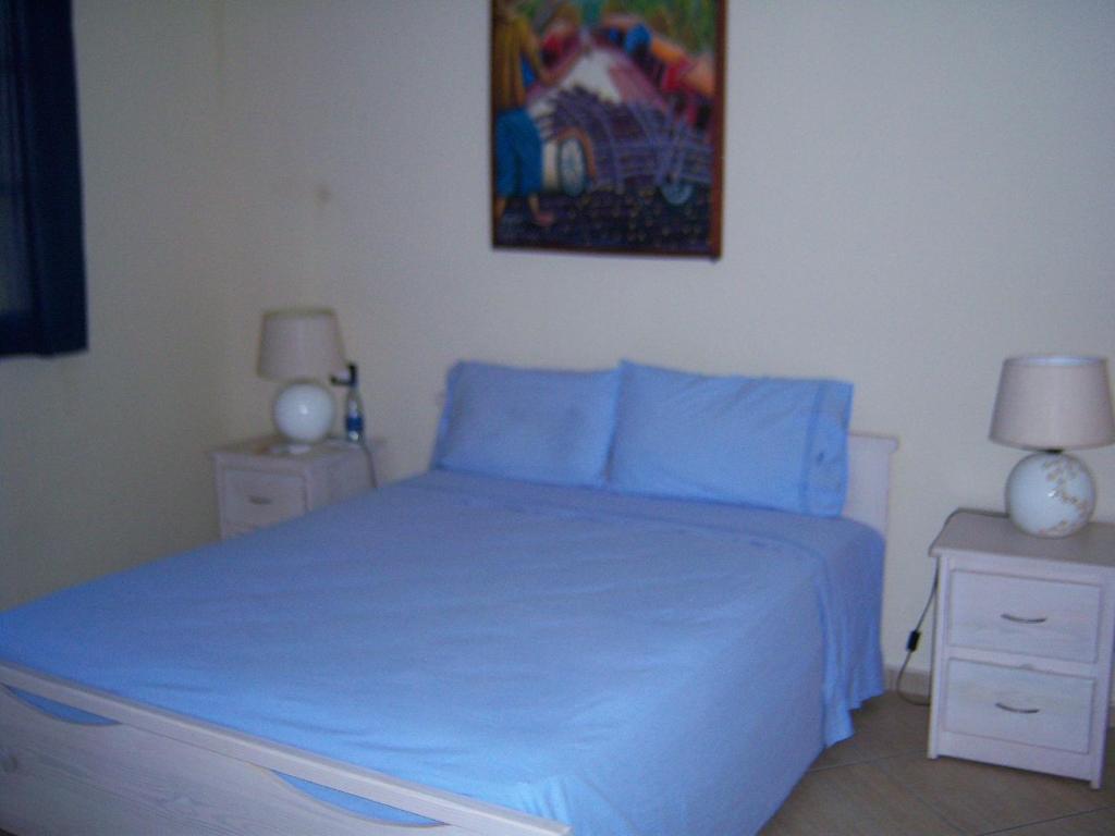 a bedroom with a blue bed with two night stands at Marina Bay in Boca Chica