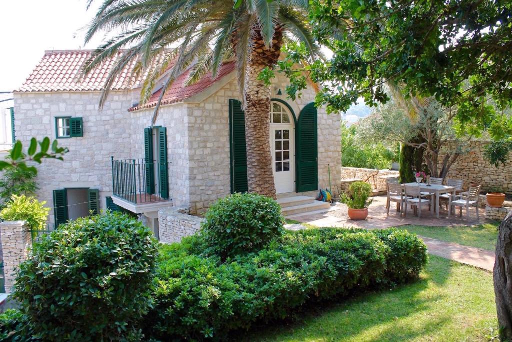 a house with green shutters and a table and chairs at Villa St Roko - Charme Homes in Sutivan