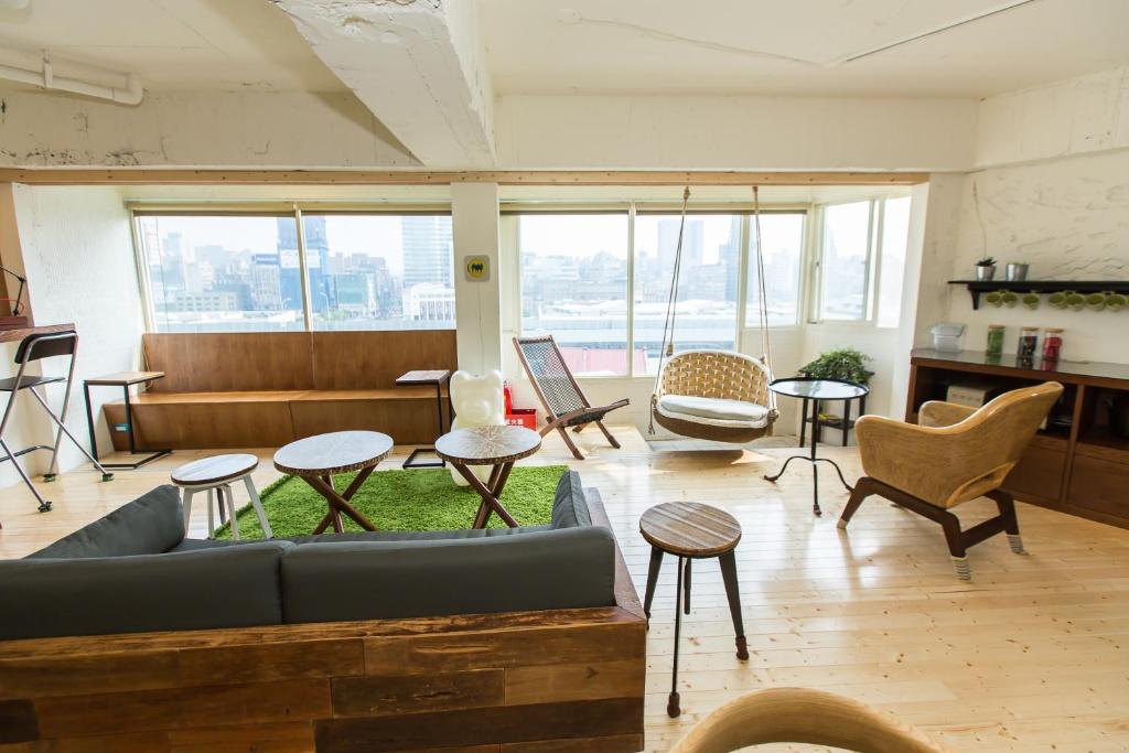 a living room with a couch and tables and chairs at Mr. Lobster’s Secret Den design hostel in Taipei