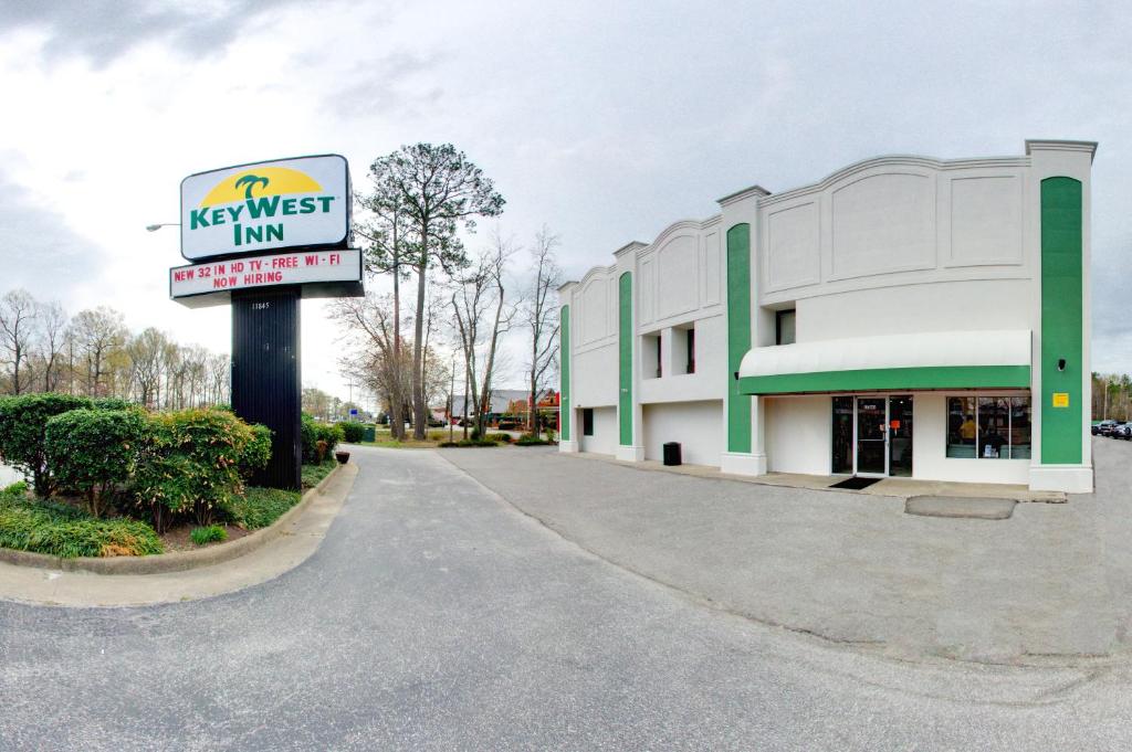 a next west inn sign in front of a building at Key West Inn - Newport News in Newport News