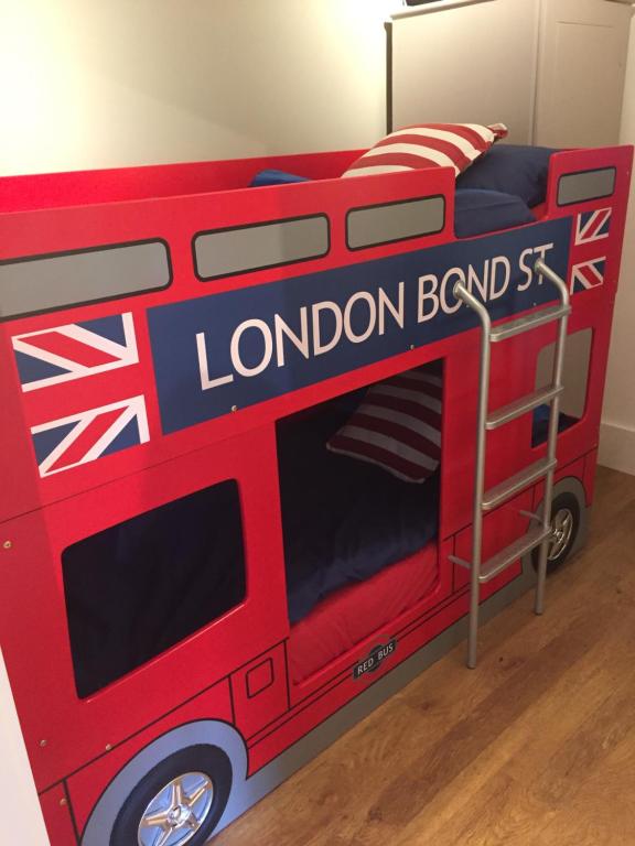 una cama doble roja de autobús con las palabras "autobús london" en Willow Court Farm The Lodge & Petting Farm, 8 mins from Legoland & Windsor, 15 mins from Lapland UK, en Windsor